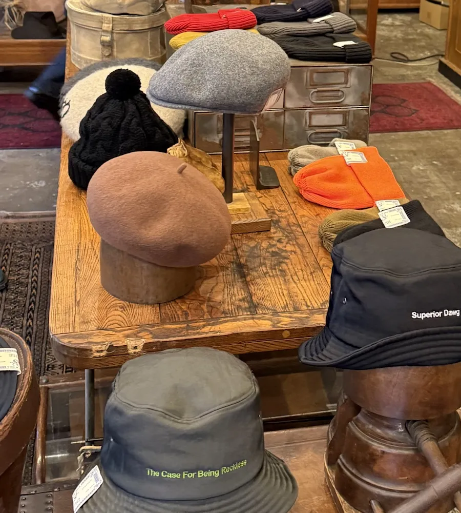 店内のテーブルに、ベレー帽やニット帽、バケットハットが並んでいる
