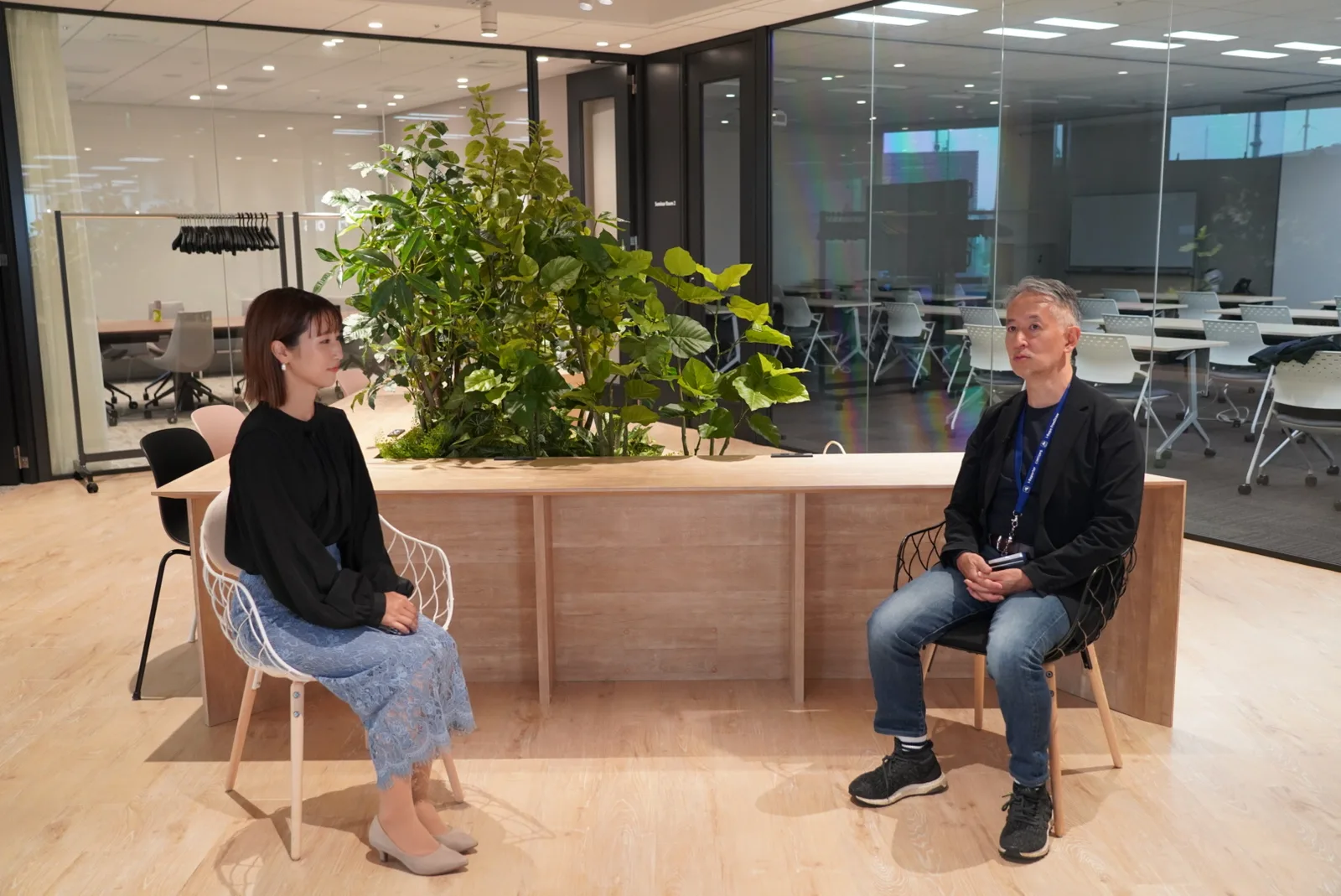 シムトップス本社のオフィスで、水野様にお話をうかがう様子